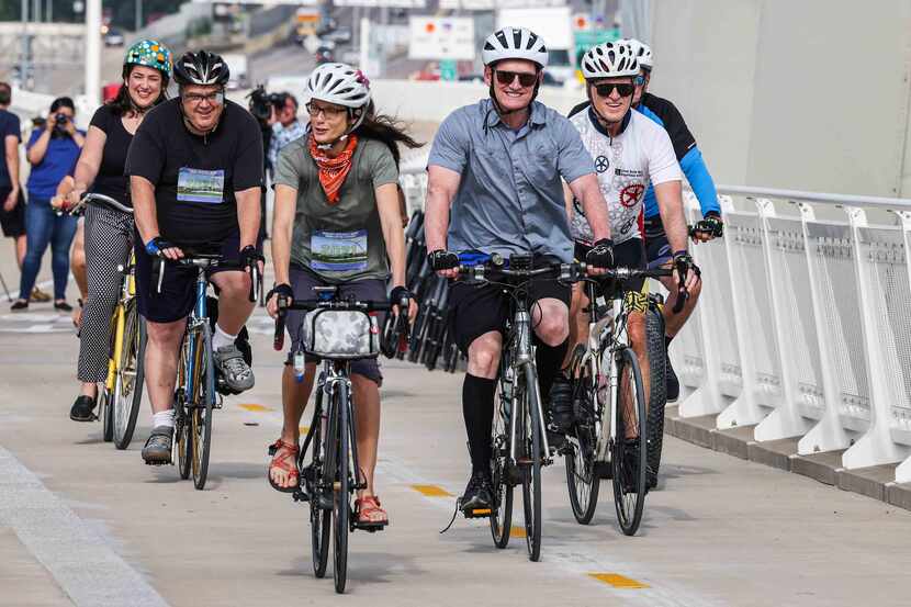 Dallas County Judge Clay Jenkins and a group of cyclists ride their bikes during the opening...