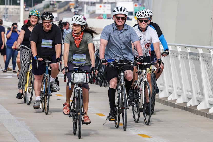 Dallas County Judge Clay Jenkins and a group of cyclists ride their bikes during the opening...