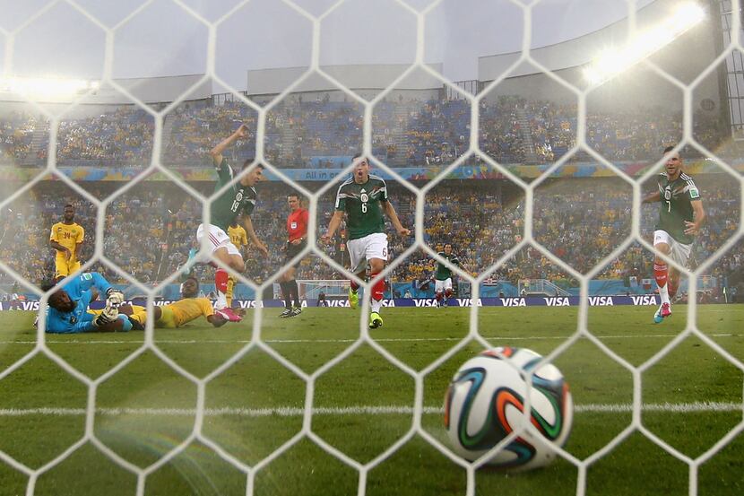 Mexico's Marco Fabian left, and Francisco Rodriguez compete to head the ball during a...