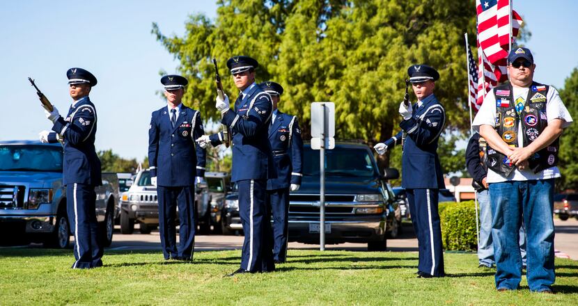 A nine-gun salute is performed by a military honor guard during funeral services for retired...