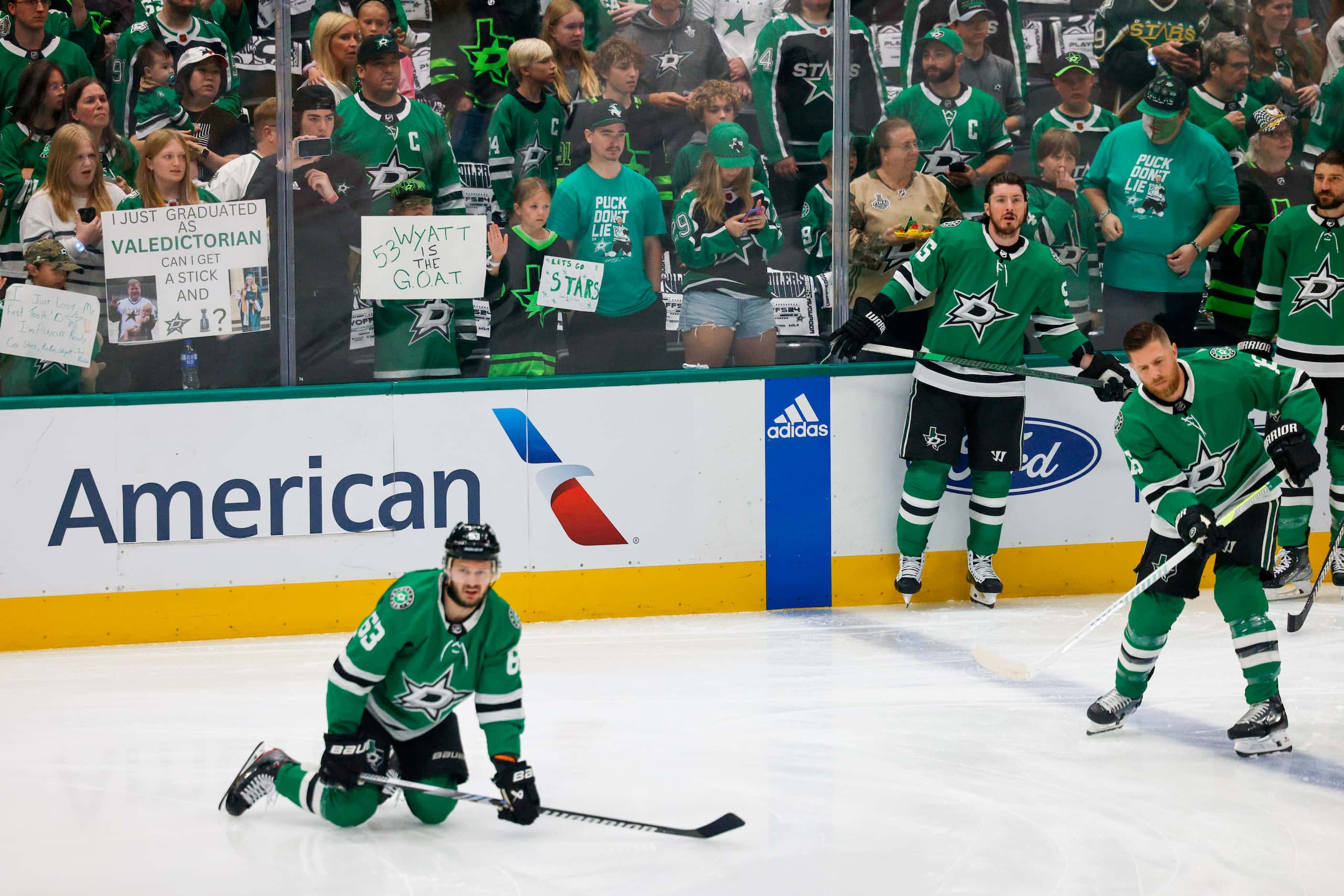 Dallas Stars fans hold signs as they watch player warmups before Game 2 of the NHL hockey...
