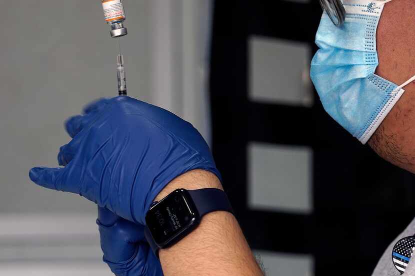 Brian Vilayvanh (cq) does vaccine prep during the drive-thru event at Fair Park in Dallas,...