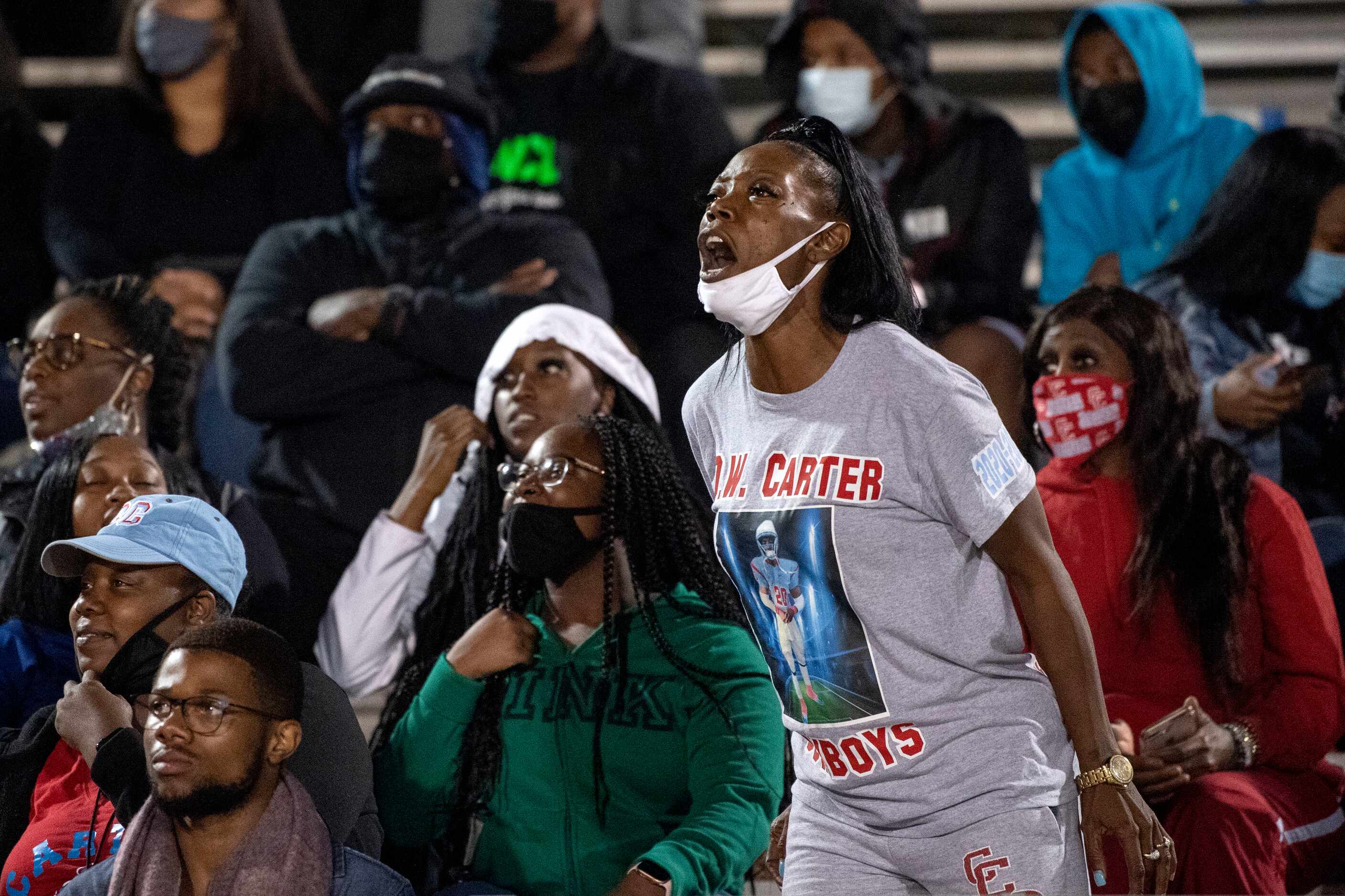 Keisha Mitchell, mother of Carter senior defensive back Jy’Quavion Vinson, yells from the...
