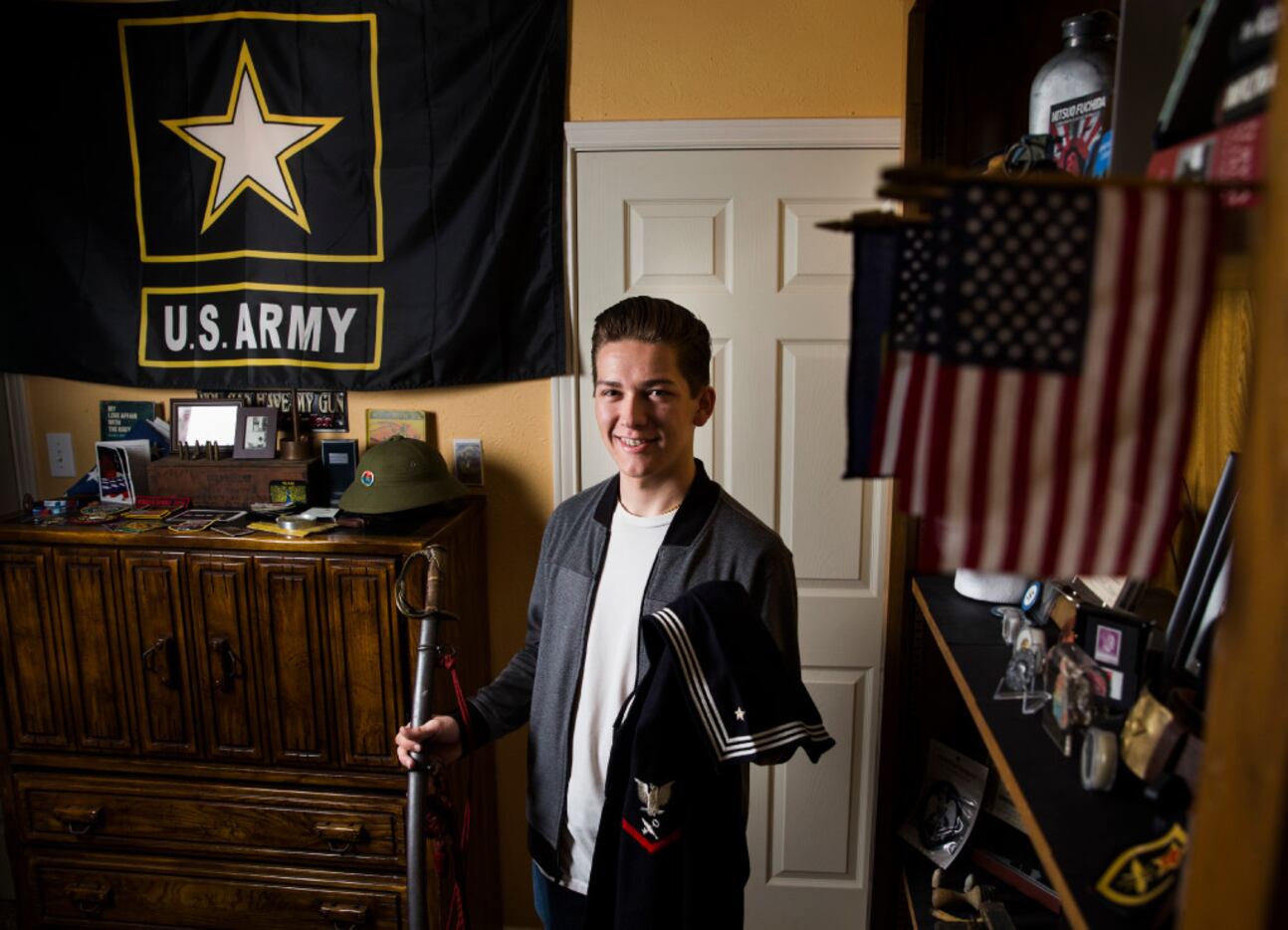 Andy Fancher, 18, holds a Civil War saber that's a family heirloom and a WWII Navy uniform...