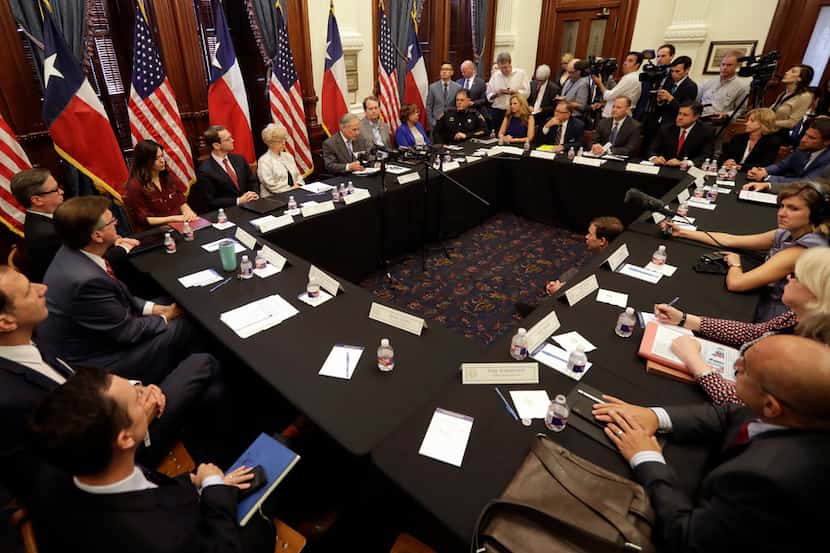 Texas Gov. Greg Abbott, at microphones at center, hosts a roundtable discussion to address...