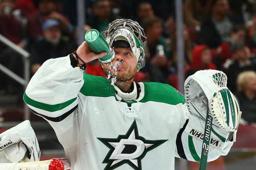 Dallas Stars goaltender Anton Khudobin spits out water after giving up a goal to Arizona...