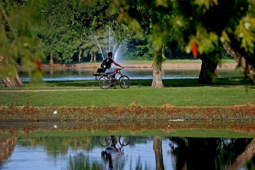 A man rides a bicycle at Towne Lake Recreation Area in McKinney on July 17, 2019.