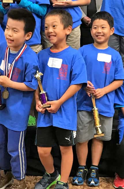 Three young competitors get ready to pose for a group photo at CIE-USA DFW Chapter's Math...