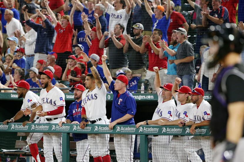 The Texas Rangers dugout reacts after third baseman Adrian Beltre (29) hit an single to...