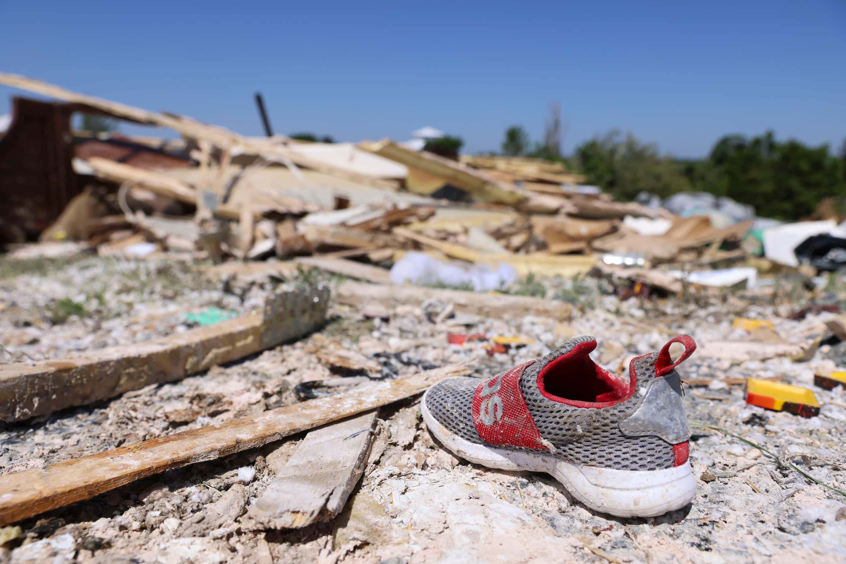 A single kid sized shoe remain within other debris collected after a tornado moved through...