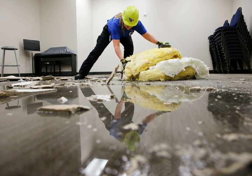 As water pools on the floor, Lisa Martin of Allen, a volunteer with the Minuteman Disaster...