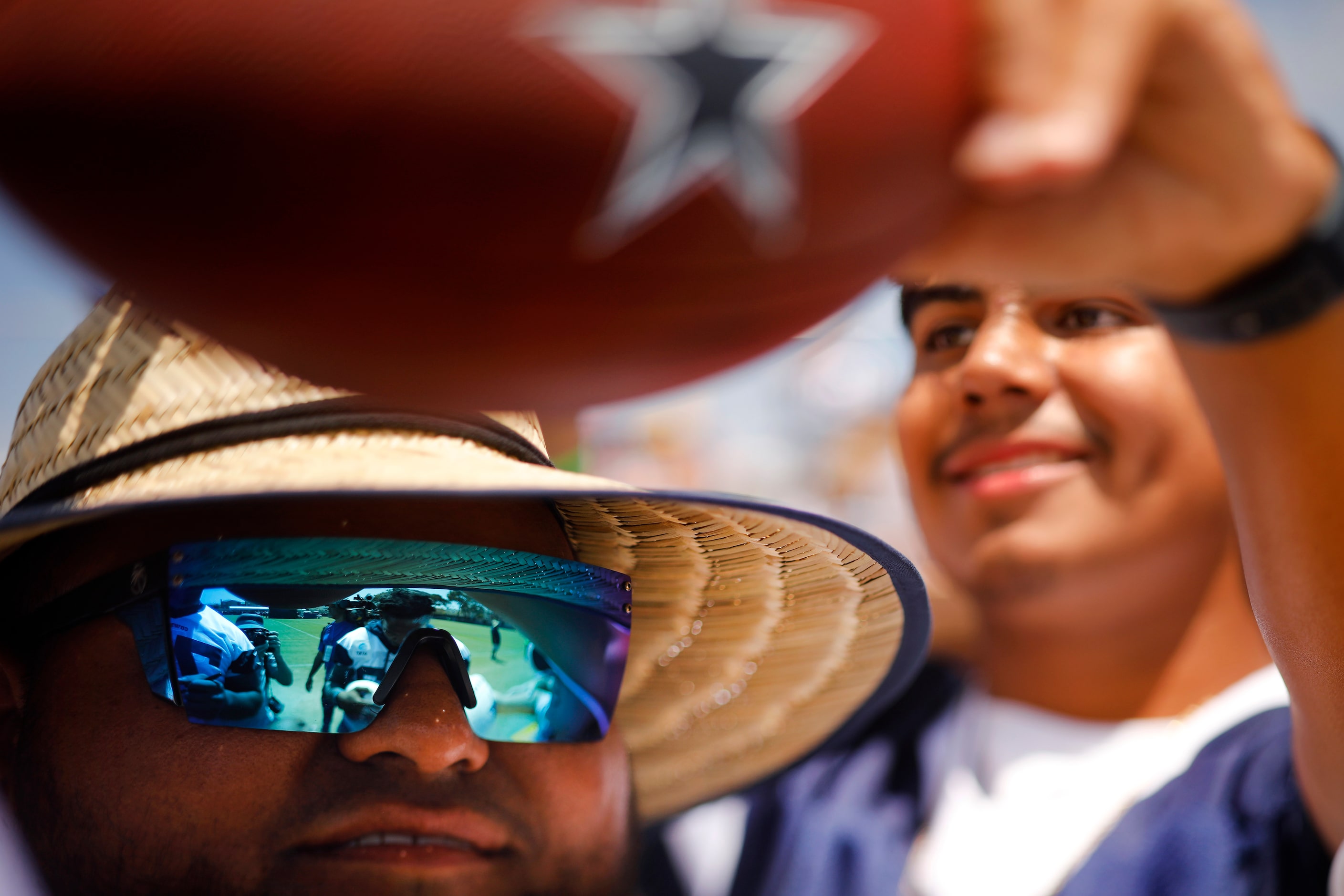 Dallas Cowboys fans, including Patrick Milan of Gardena, California (left) reach for an...