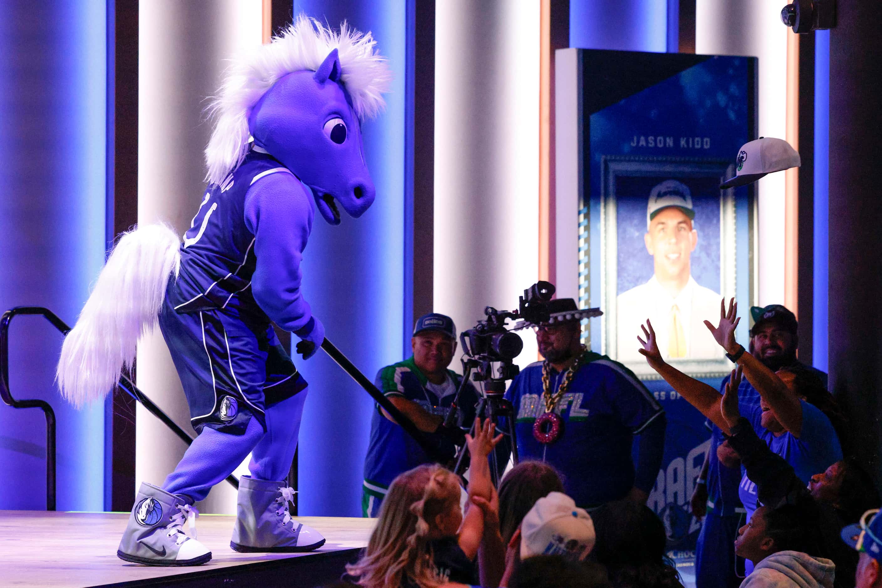 Dallas Mavericks mascot Champ tosses a hat to fans during a 2023 NBA Draft watch party at...