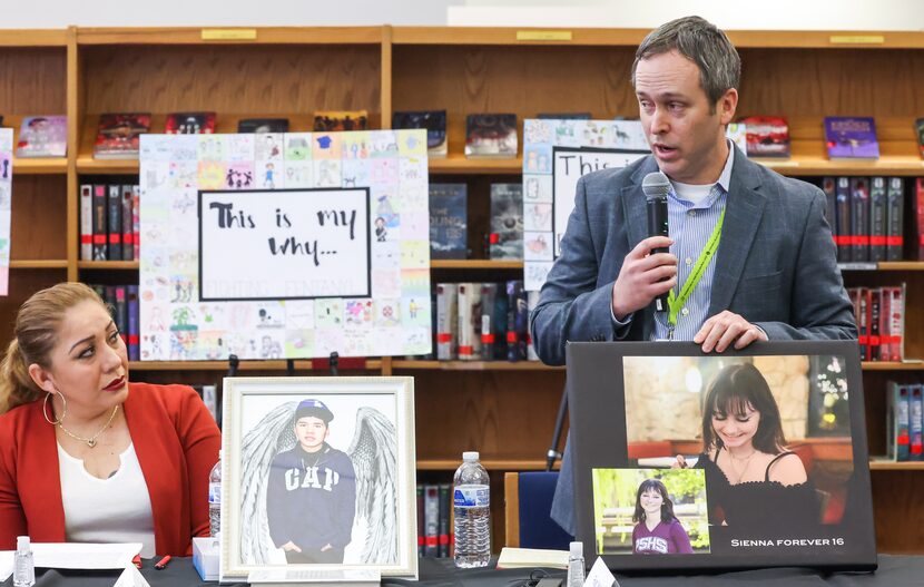 Lilia Astudillo (left) looks up at Ryan Vaughn (right) as he holds up images of his...