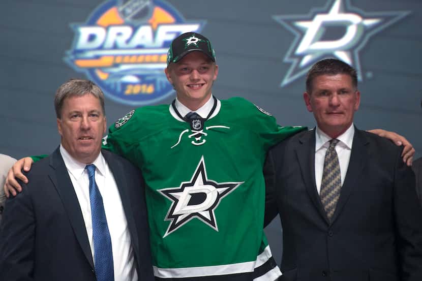 Riley Tufte, center, stands with members of the Dallas Stars management team at the NHL...