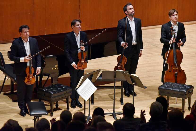 The Modigliani String Quartet stands to an applauding audience during a concert presented by...