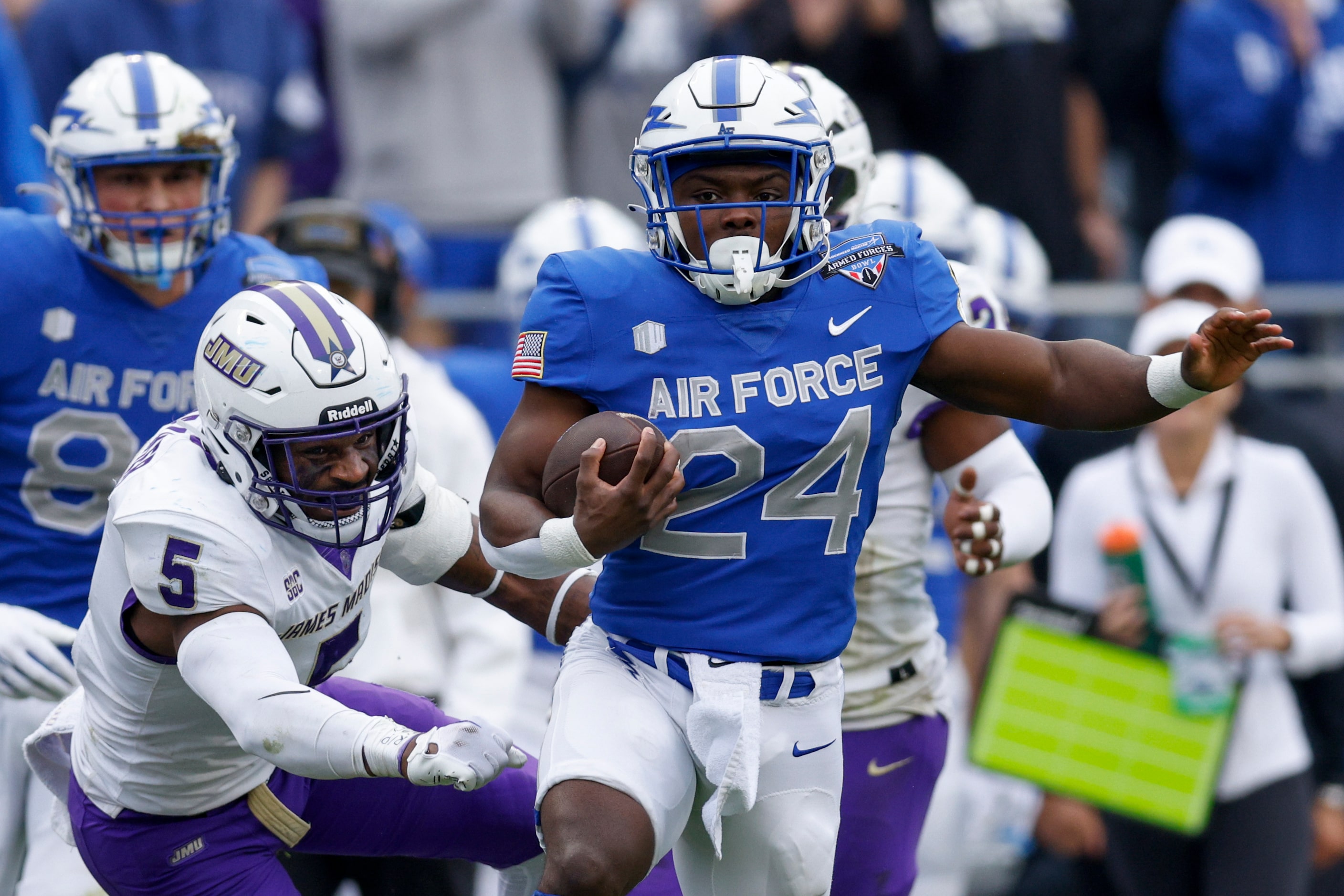 Air Force Falcons running back John Lee Eldridge III (24) slips a tackle from James Madison...