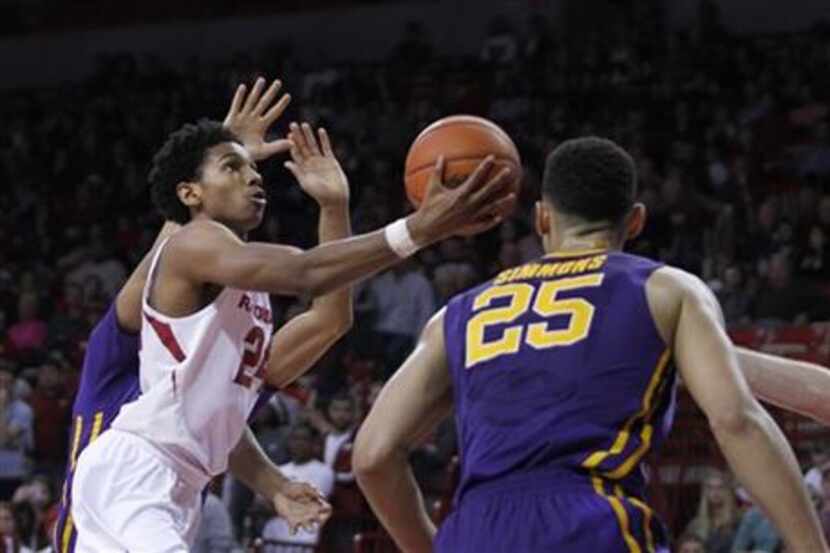 Arkansas' Jimmy Whitt, left, moves toward the basket for a layup during the first half of an...