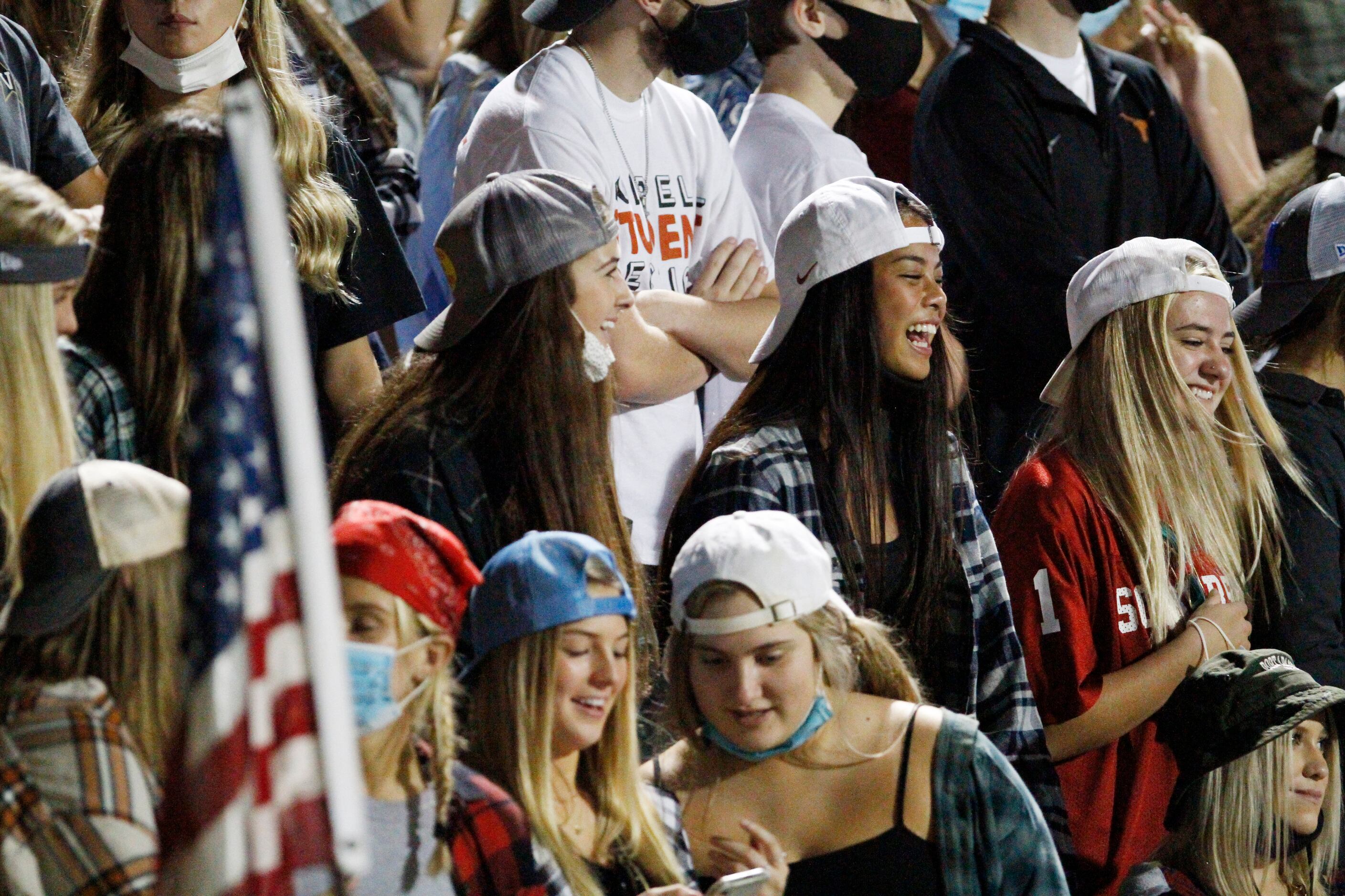 Coppell High School students stand on the bleachers watching the football game versus...