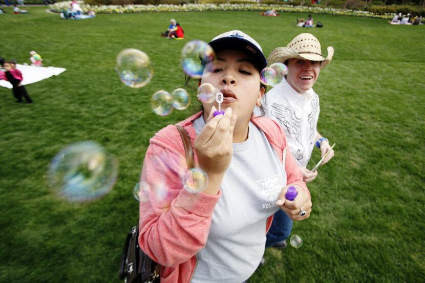 Ana Pi-a, of Fort Worth, blows bubbles while walking in the Jonsson Color Garden with Danny...
