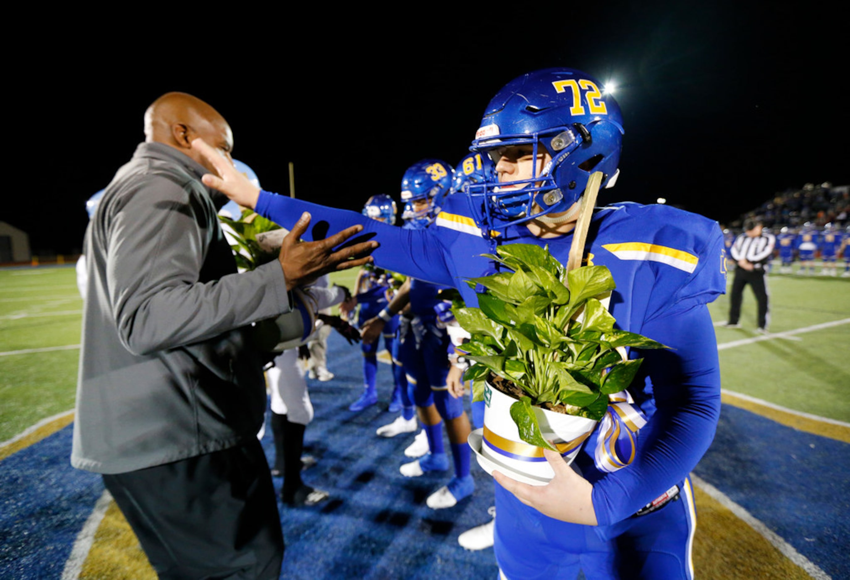 Community High football captain Eli Hartley (right) thanks Dallas Roosevelt head coach Aaron...