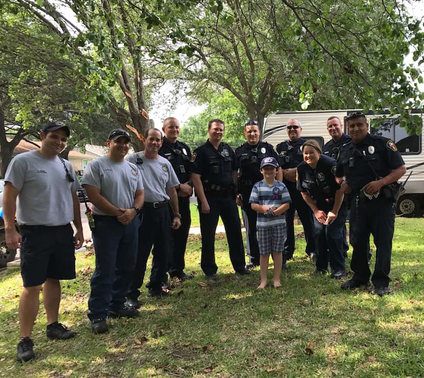 Graham Day, 8, with a Hurst police officers and firefighters who celebrated his birthday...