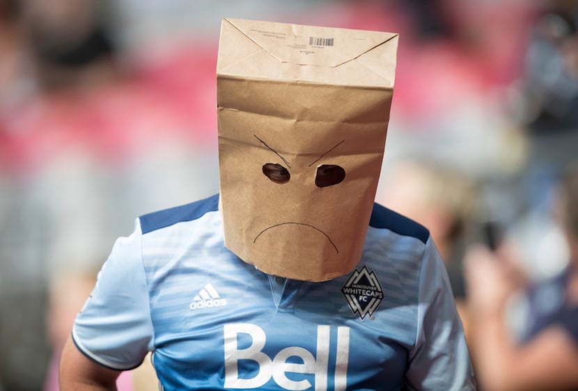 A Vancouver Whitecaps supporter wears a paper bag on his head as the Whitecaps and the San...
