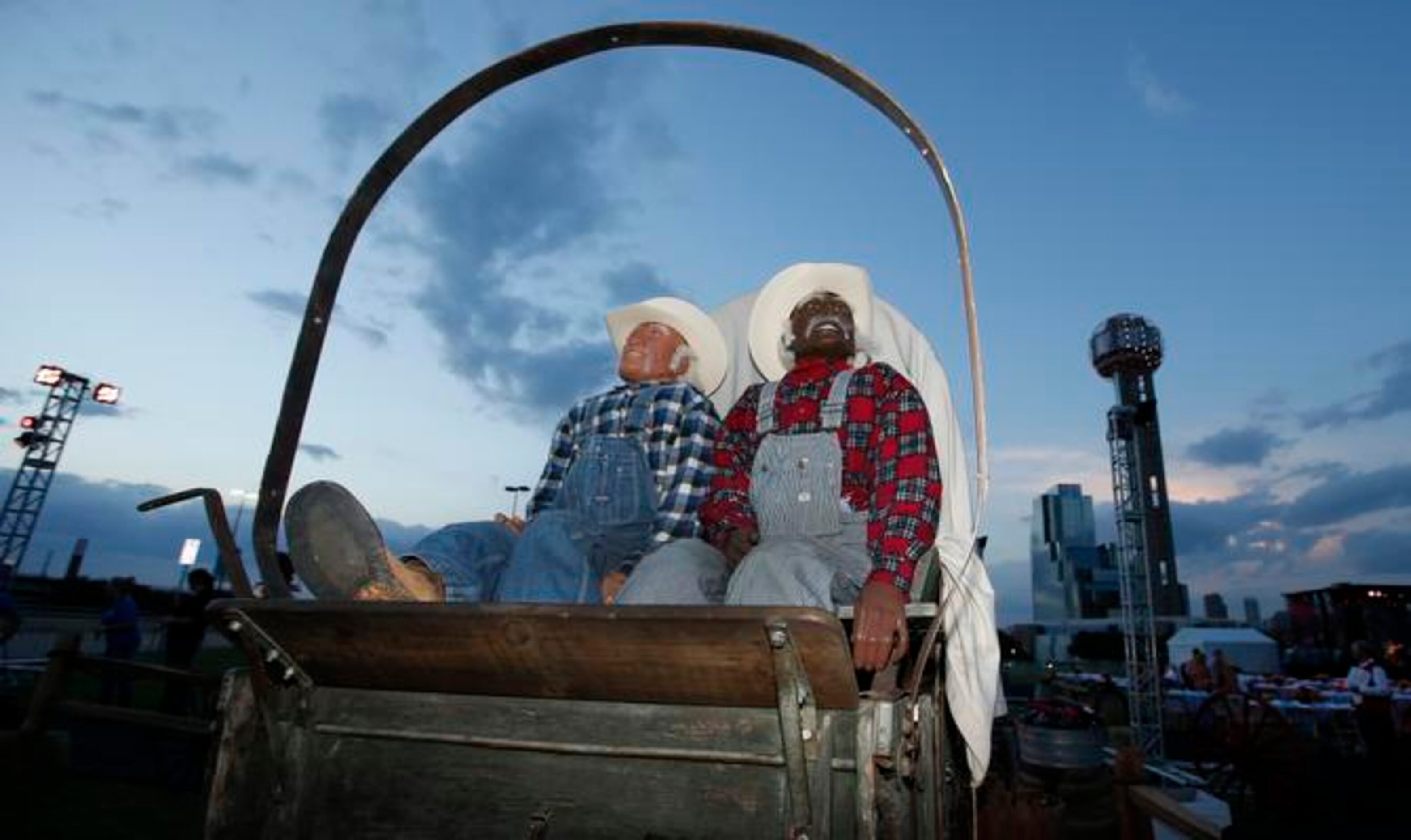 
Two mannequins dressed as cowboys greet attendees as Reunion Tower will puts on a fireworks...