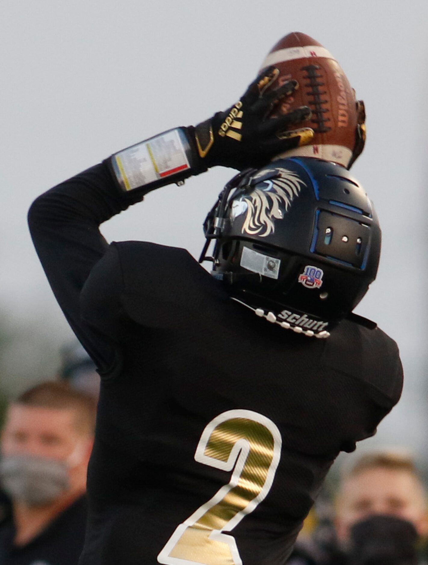 Kaufman receiver Daylon Dickerson (2) cradles the ball against his helmet before turning...