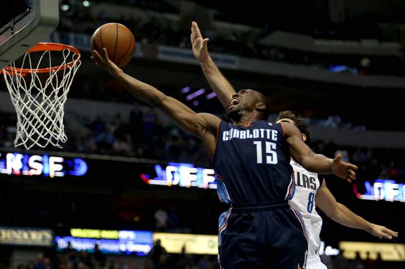 Charlotte Bobcats point guard Kemba Walker (15) goes up for a basket guarded by Dallas...