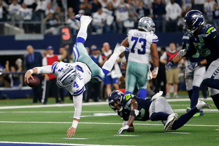 Dallas Cowboys quarterback Dak Prescott (4) dives for more yards but is stopped by Seattle...