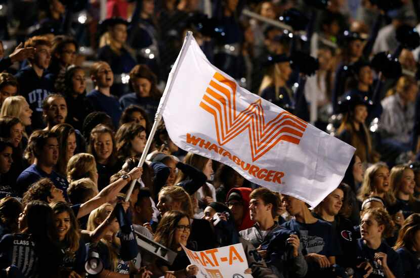 Frisco Lone Star senior Dalton Light waves a Whataburger flag as fans cheer in a game...