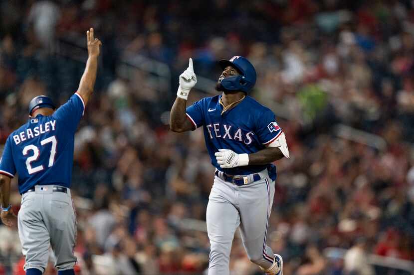 Texas Rangers right fielder Adolis Garcia, right, celebrates with third base coach Tony...