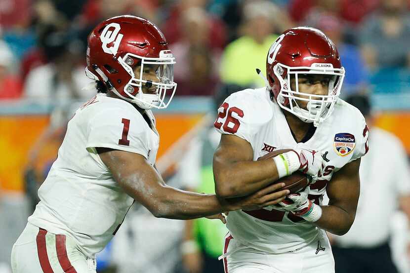 MIAMI, FL - DECEMBER 29: Kyler Murray #1 of the Oklahoma Sooners hands it off to Kennedy...