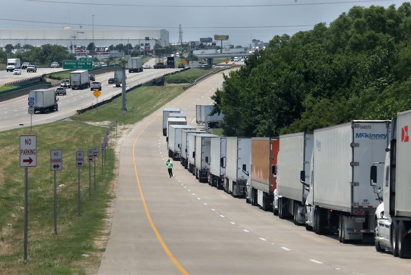 A long line of delivery trucks waits to enter an Amazon fulfillment center in Dallas.