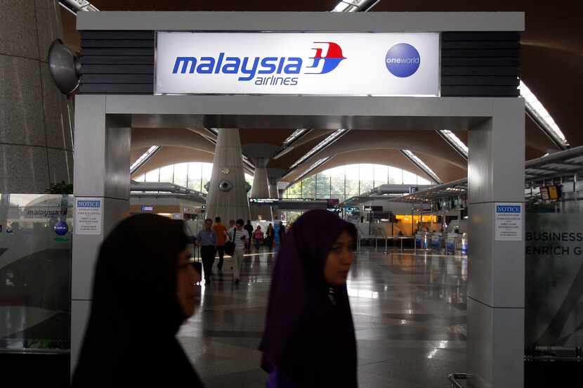 Passengers walked past a sign of Malaysia Airlines at Kuala Lumpur International Airport in...