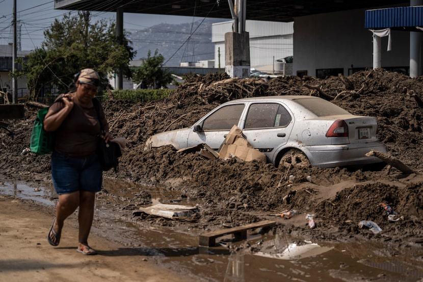 Una mujer camina por una zona dañada tras el paso del huracán Otis, el domingo 29 de octubre...