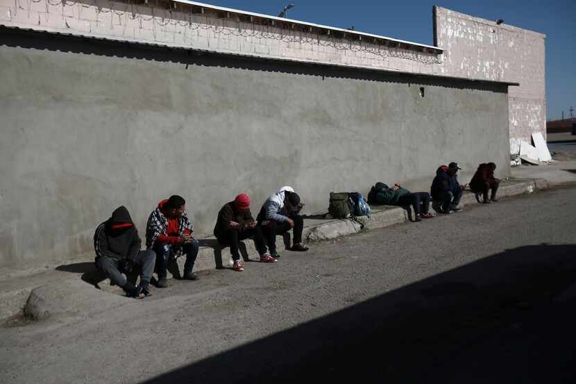 Migrantes sentados junto a un albergue en la ciudad fronteriza de Ciudad Juárez, en México,...