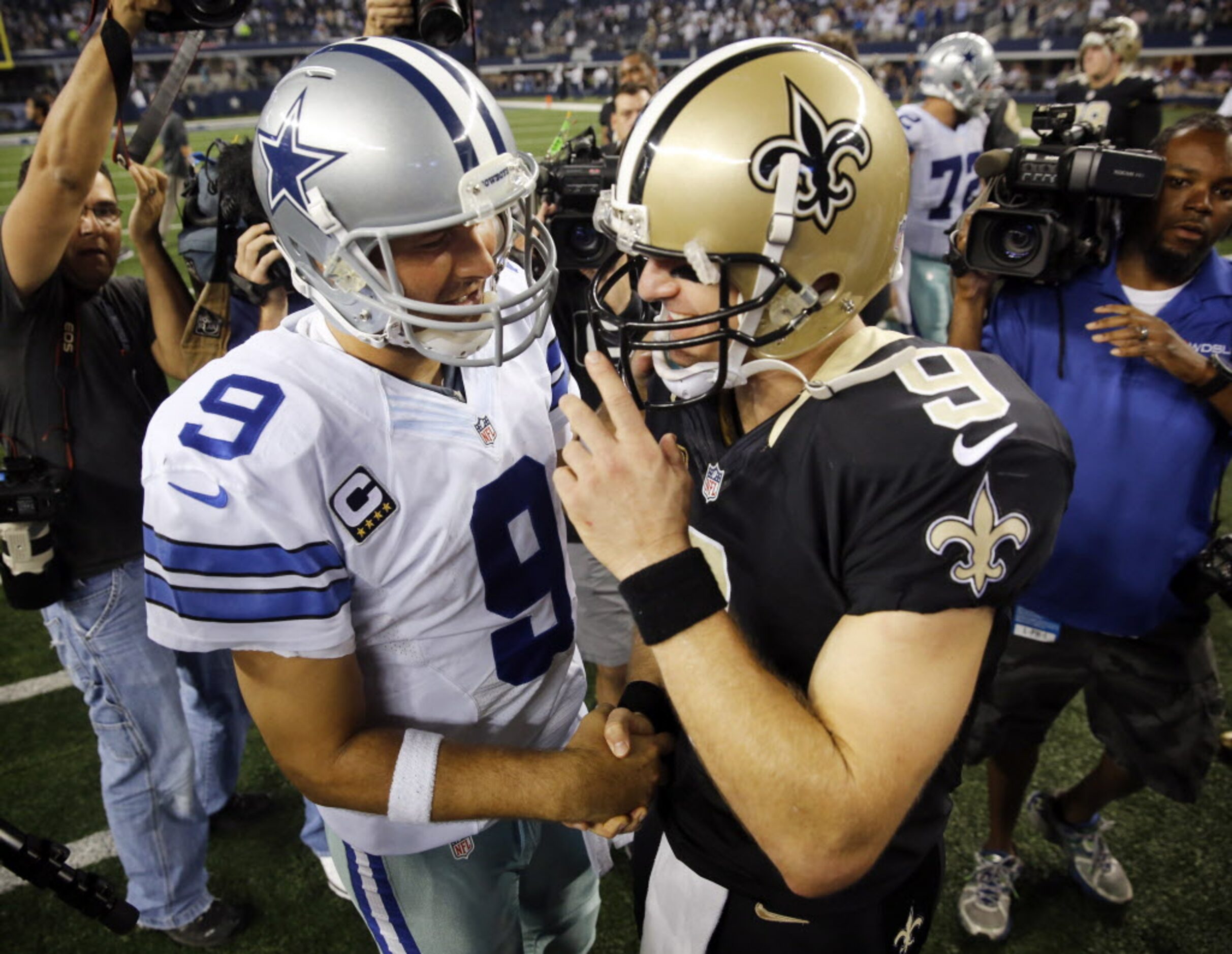 Dallas Cowboys quarterback Tony Romo (9) and New Orleans Saints quarterback Drew Brees (9)...