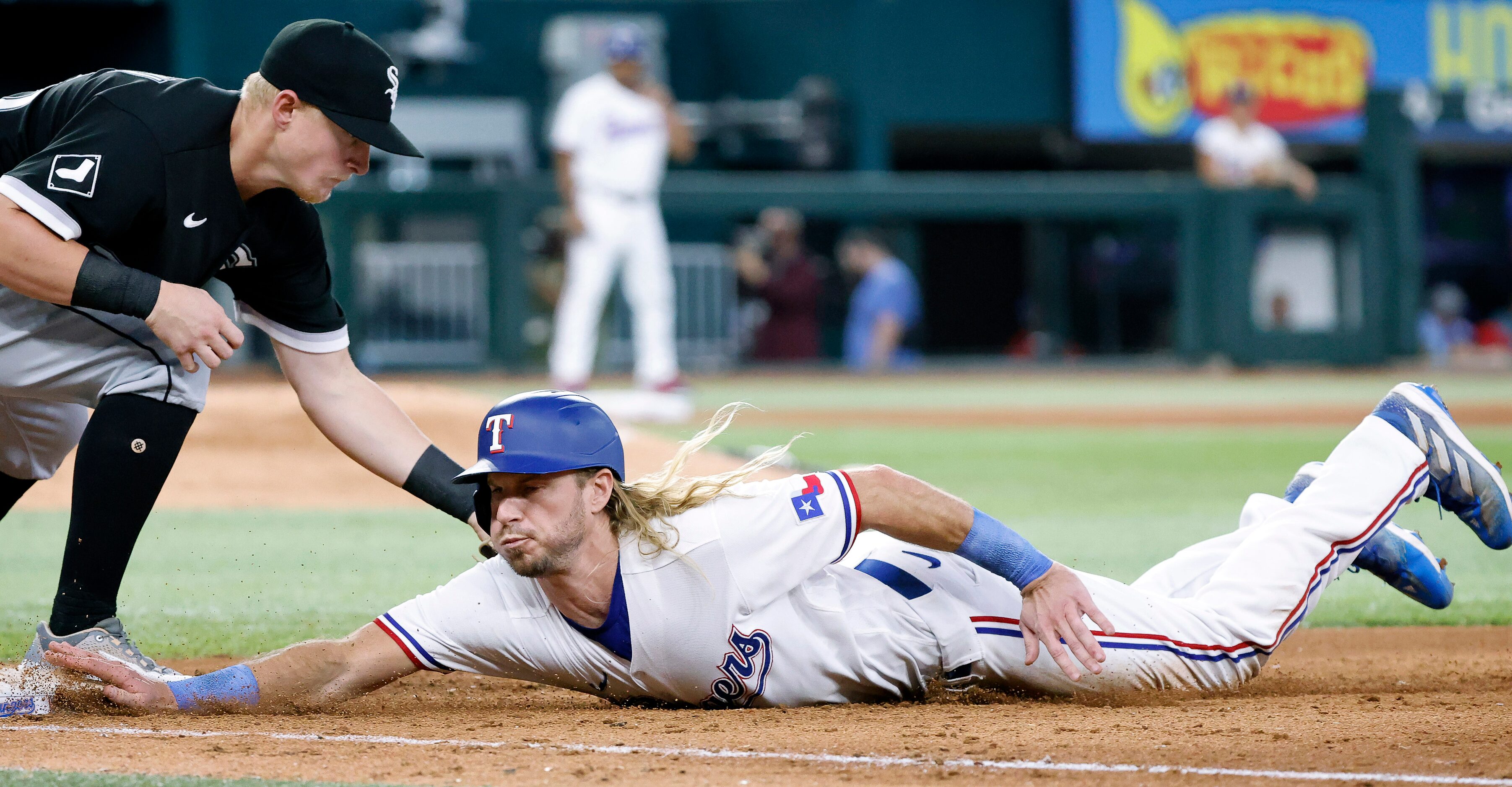 Texas Rangers Travis Jankowski (16) dives back to first base ahead of the pick off attempt...