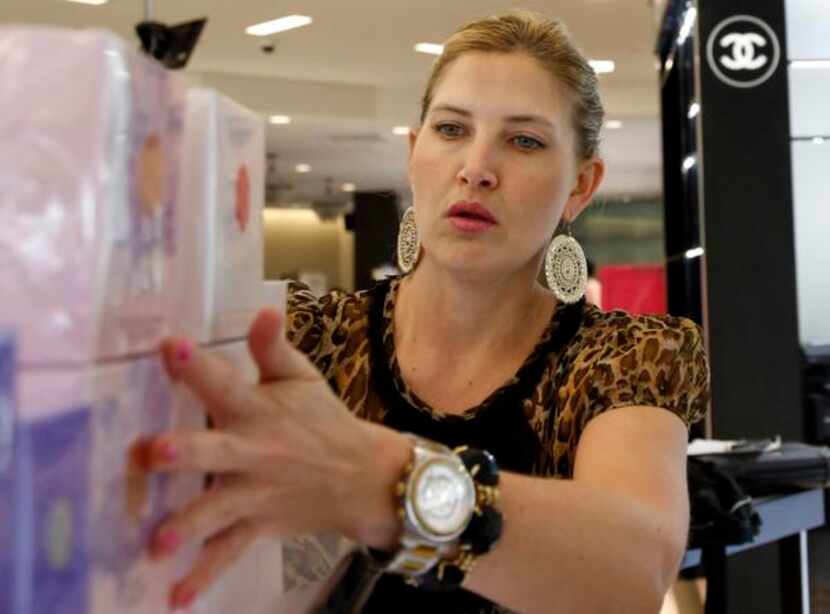 
Courtney Watson lines up perfume at the Belk store in Galleria Dallas. The retailer has 14...