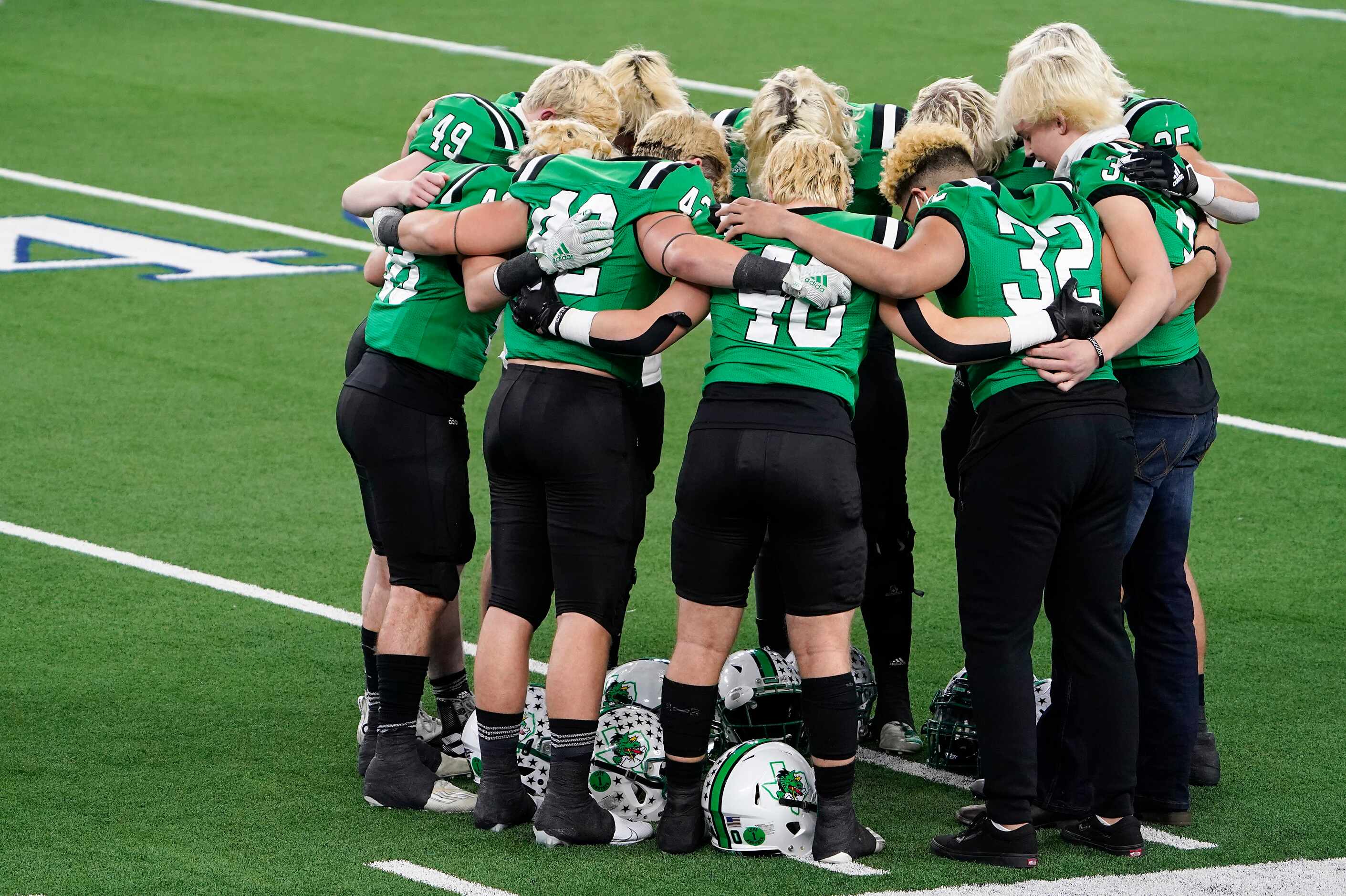 Southlake Carroll players huddle on the field before the Class 6A Division I state football...