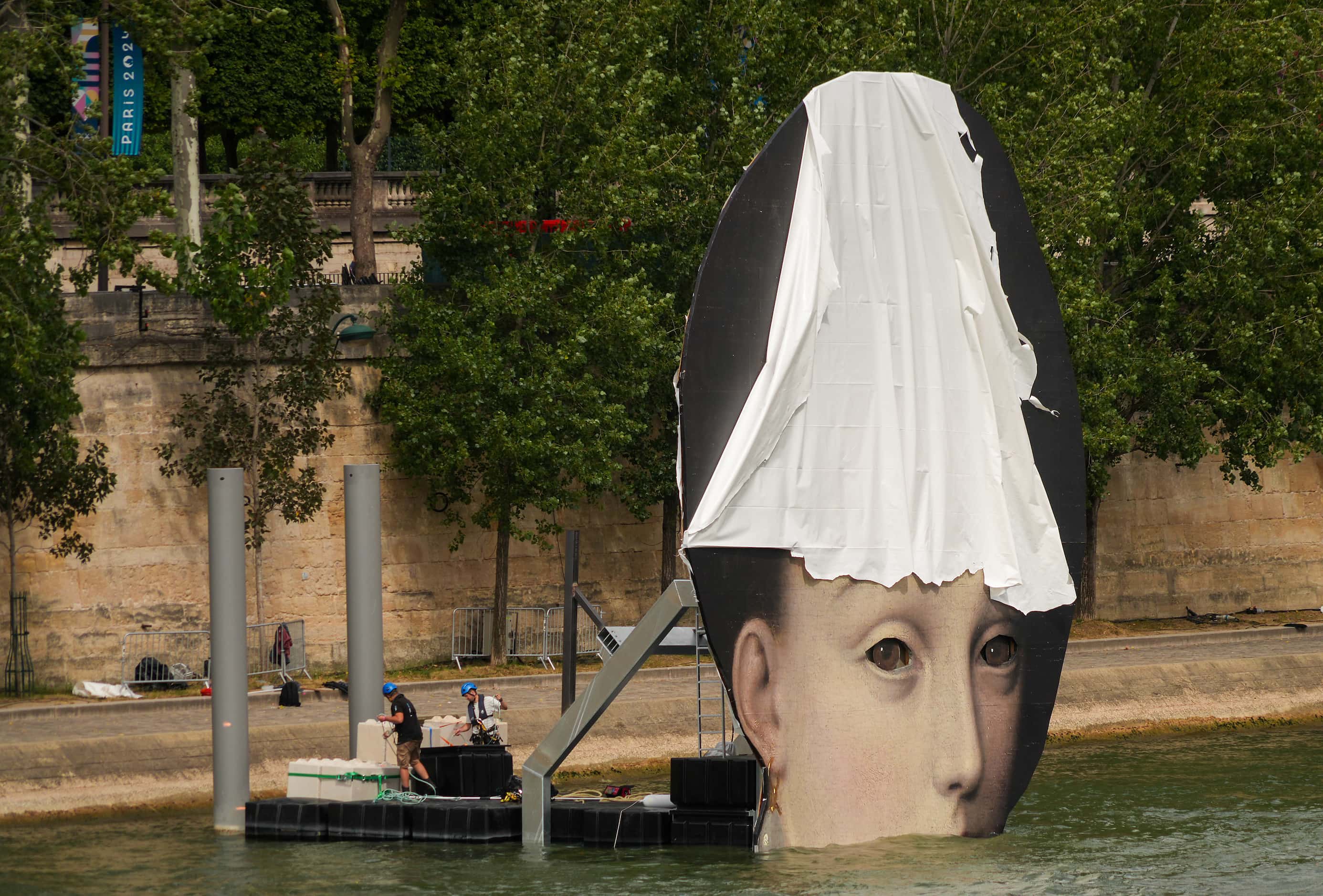 Workers make preparations for opening ceremonies along the River Seine ahead of the 2024...