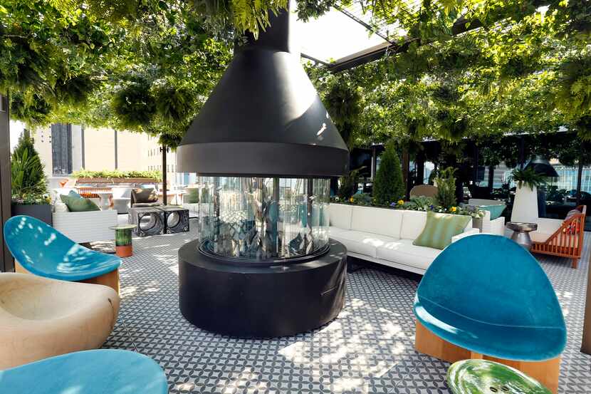 A large fireplace and funky furniture are pictured on the Catbird outdoor patio area of the...