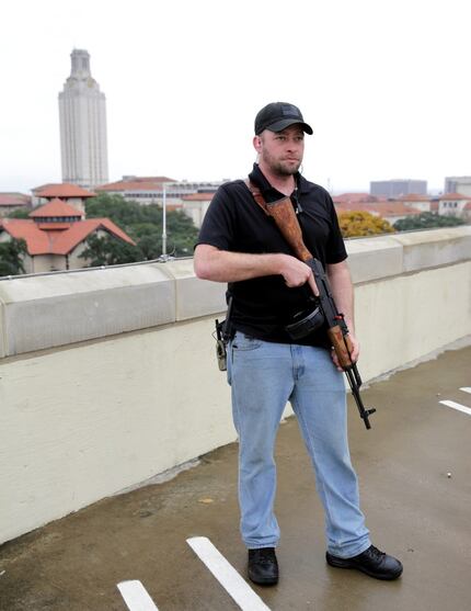  Gun rights activist Michael Short holds a gun as he prepares for a march near the...