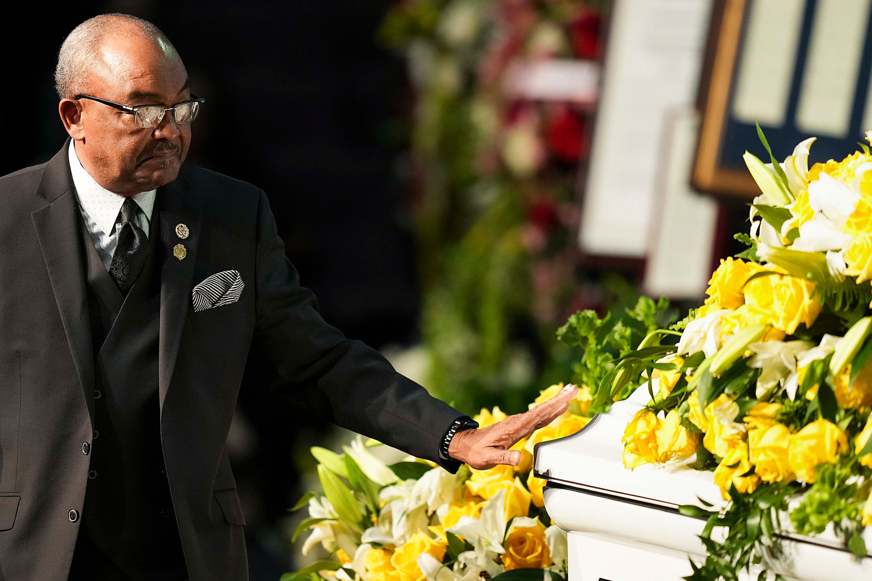 Kirk Johnson reaches out to touch his mother’s casket after sepaking during funeral services...