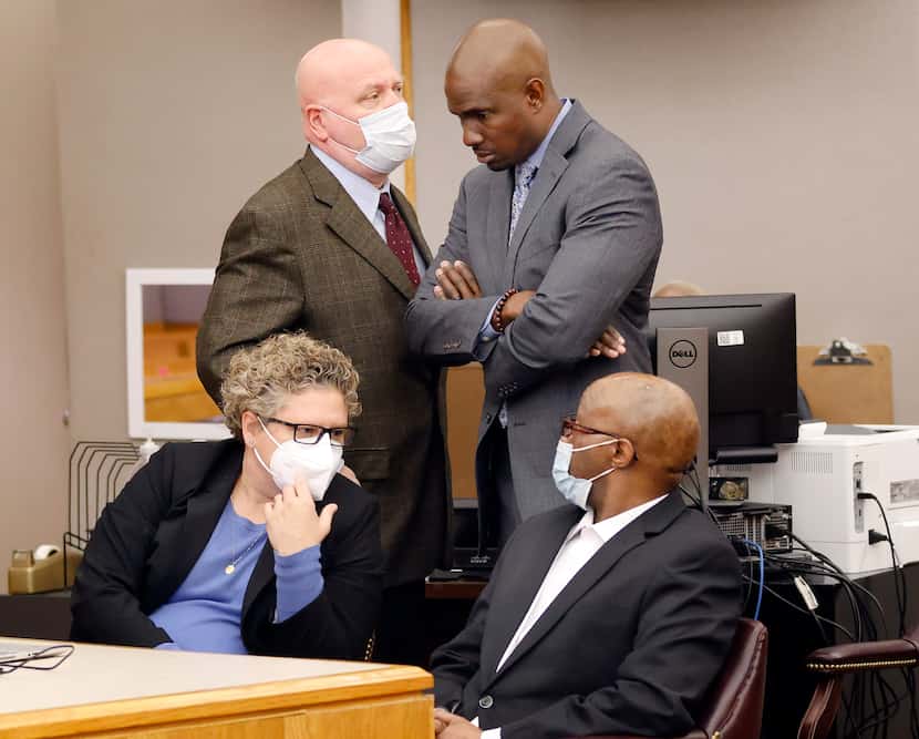 Defense attorney Kobby Warren (standing right) confers with fellow attorney Mark Watson....