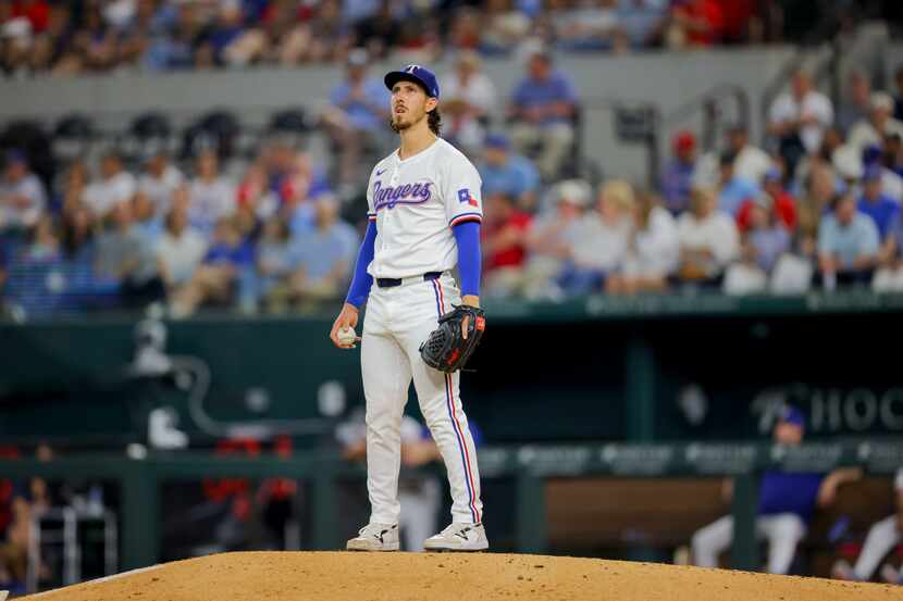 Texas Rangers starting pitcher Michael Lorenzen pauses between pitches during the fourth...
