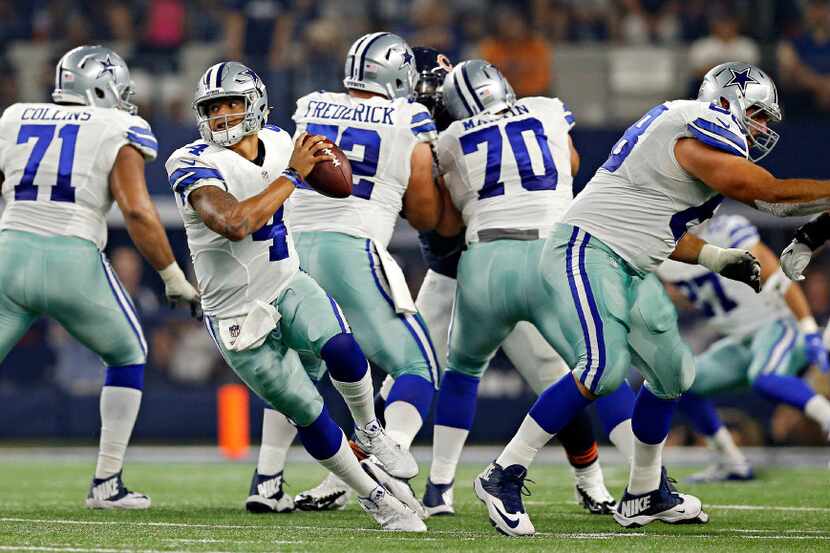 Dallas Cowboys quarterback Dak Prescott (4) spins around as he escapes trouble during the...
