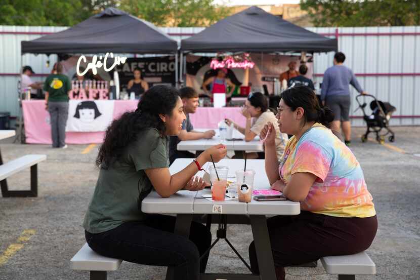 Ramona Canizales (left) and Estefania Enriquez (right) enjoy drinks and sweets from a...
